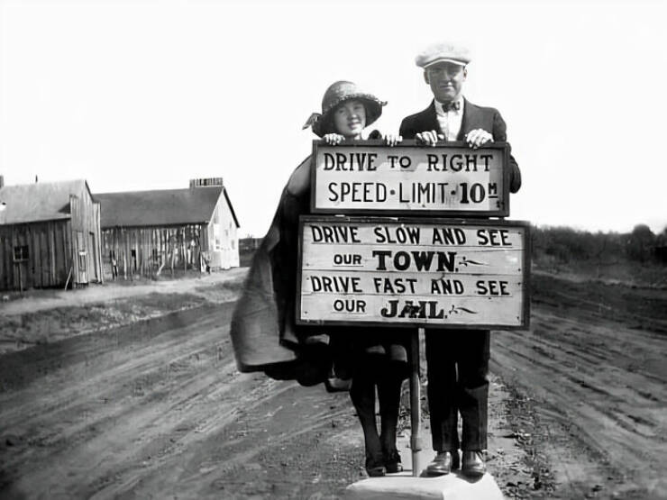 Молодая пара, стоящая у знака ограничения скорости. Оклахома, 1920-е годы